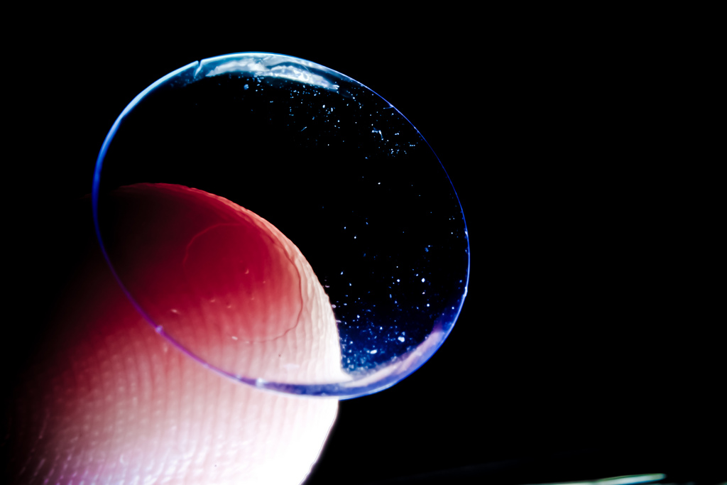 Existe diferença entre lentes de contato tóricas e rígidas dedo segurando lente de contato